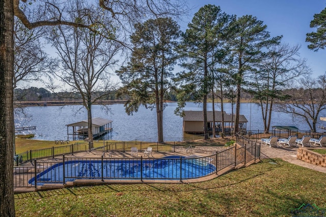 view of swimming pool with a yard, a patio, and a water view