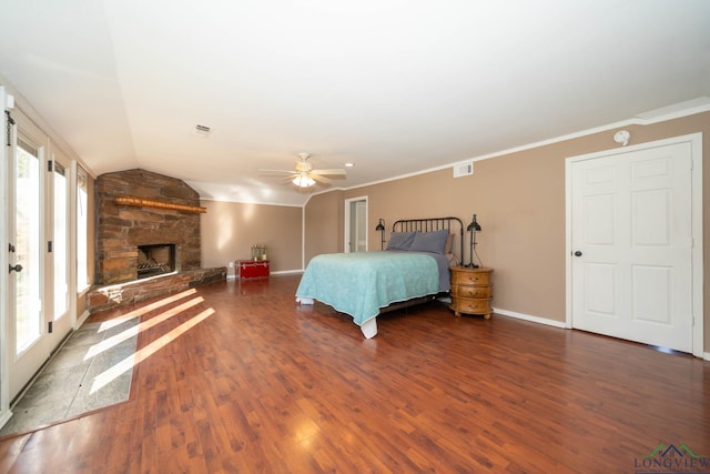 bedroom with lofted ceiling, a stone fireplace, crown molding, ceiling fan, and dark hardwood / wood-style flooring