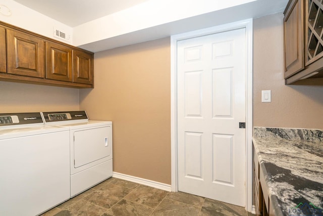 clothes washing area with cabinets and washing machine and dryer