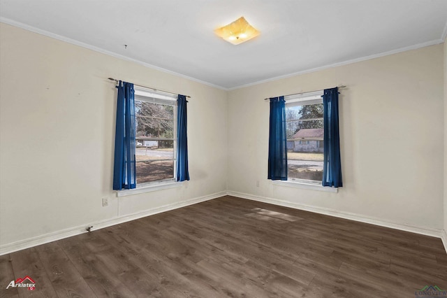 empty room featuring dark wood-style floors, ornamental molding, and baseboards