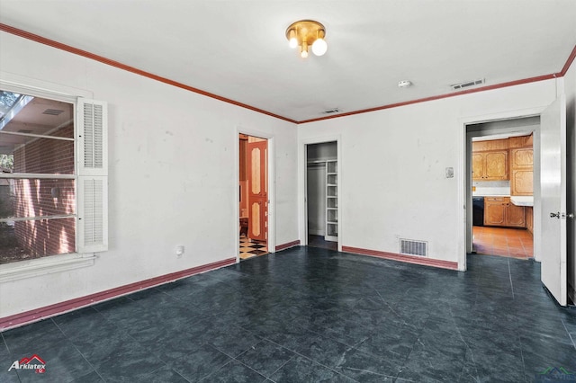 empty room with ornamental molding, visible vents, and baseboards