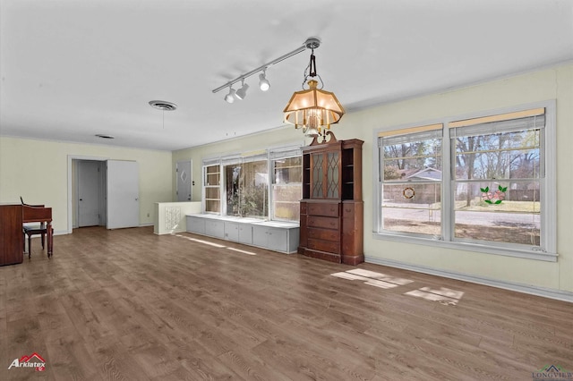 unfurnished living room with visible vents, baseboards, and wood finished floors