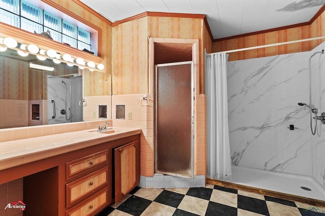 bathroom featuring tile walls, ornamental molding, a stall shower, vanity, and tile patterned floors