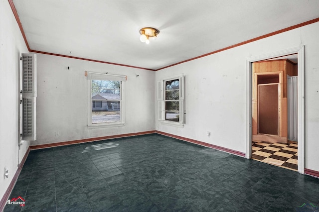 unfurnished room featuring dark floors, baseboards, and crown molding