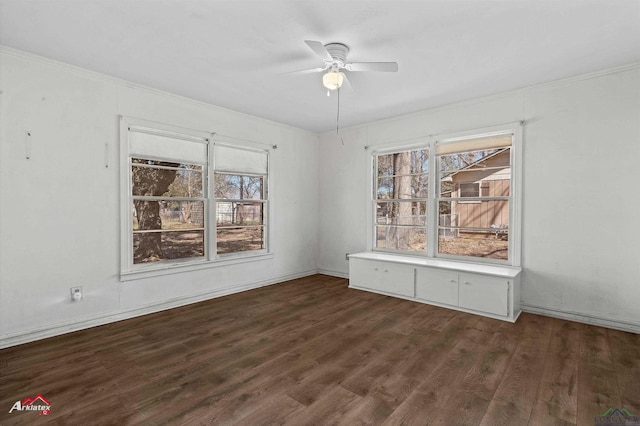 unfurnished room featuring ornamental molding, dark wood finished floors, and a ceiling fan