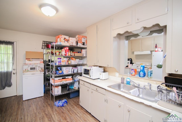 206 E Shofner Dr, Longview, TX 75604 - kitchen with white microwave, light countertops, under cabinet range hood, a sink, and light wood-style floors