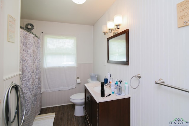 206 E Shofner Dr, Longview, TX 75604 - bathroom featuring wood finished floors, toilet, vanity, a wainscoted wall, and curtained shower