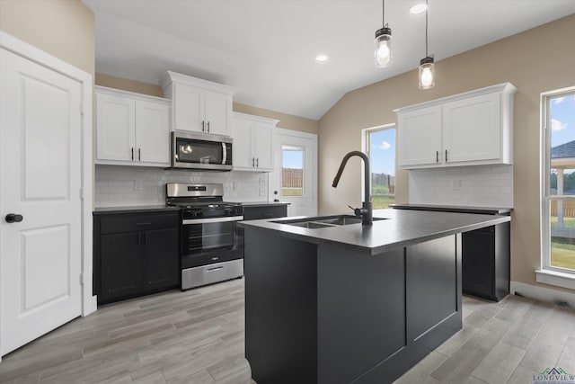 kitchen featuring appliances with stainless steel finishes, decorative backsplash, white cabinets, and sink