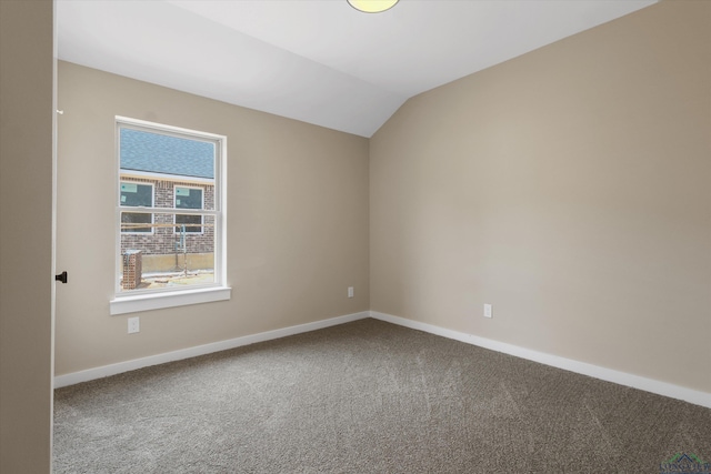 carpeted spare room featuring lofted ceiling