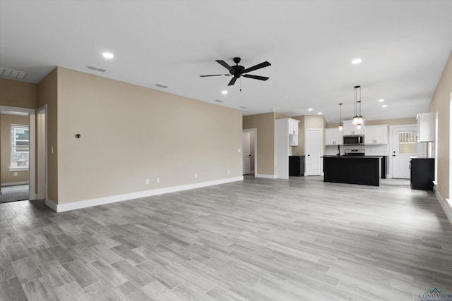 unfurnished living room with ceiling fan and light hardwood / wood-style flooring