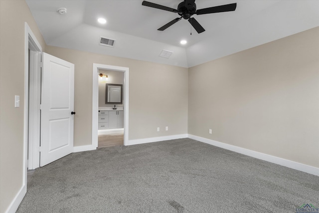 unfurnished bedroom featuring vaulted ceiling, ceiling fan, carpet floors, and ensuite bath