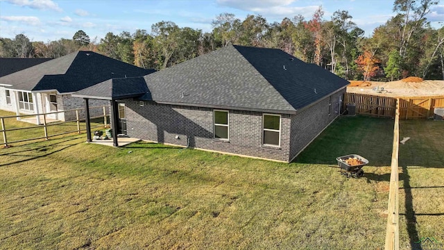 back of property featuring a patio area and a lawn