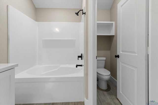 bathroom with hardwood / wood-style flooring, shower / bathing tub combination, and toilet