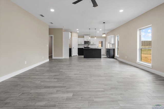 unfurnished living room featuring ceiling fan