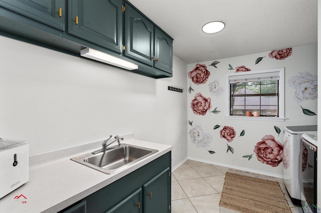 interior space with cabinets, sink, separate washer and dryer, a textured ceiling, and light tile patterned flooring