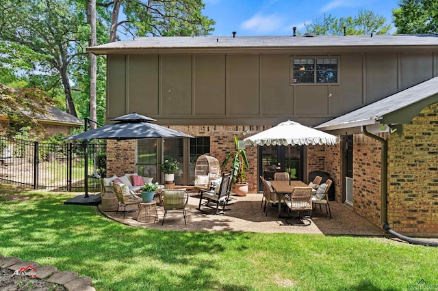 back of property with outdoor lounge area, a patio, and a lawn