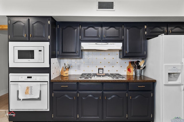 kitchen featuring white appliances and backsplash