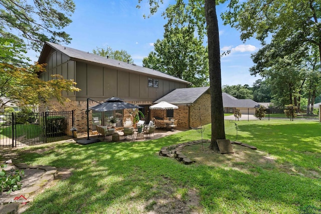 rear view of property featuring a patio area, an outdoor living space, and a yard