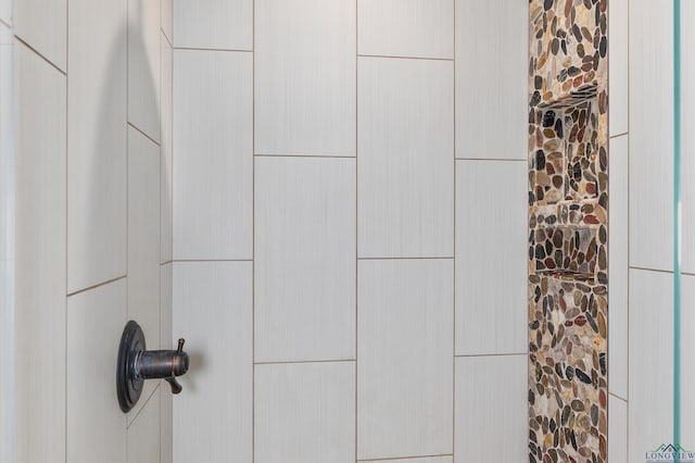 interior details featuring a tile shower