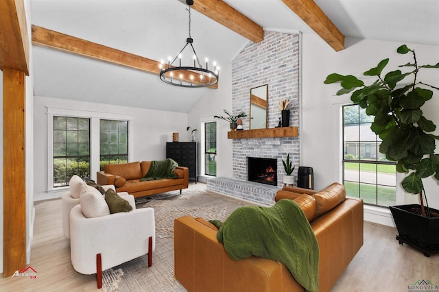 living room featuring high vaulted ceiling, a brick fireplace, light wood-type flooring, beamed ceiling, and a chandelier