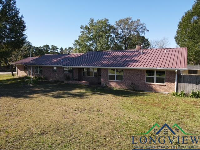 rear view of property with a lawn