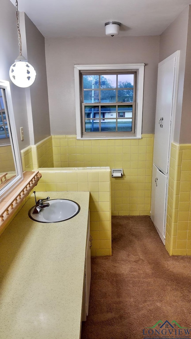 bathroom with vanity and tile walls