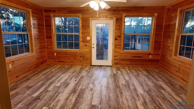 unfurnished sunroom featuring ceiling fan