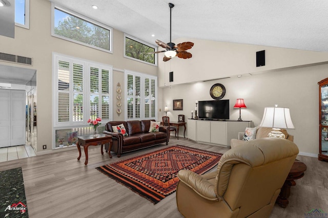 301 Tealwood Dr, Longview, TX 75605 - living area with ceiling fan, a textured ceiling, wood finished floors, high vaulted ceiling, and baseboards
