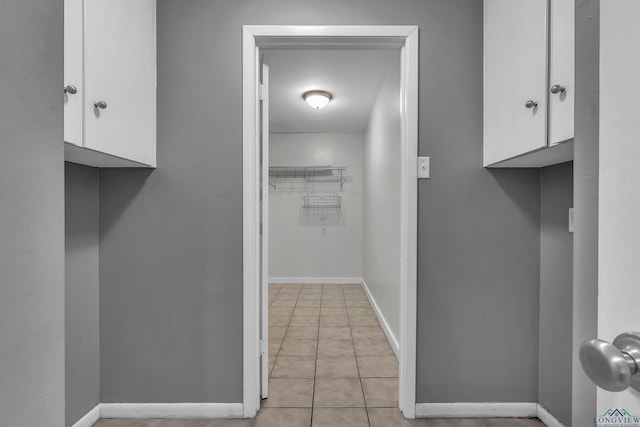 interior space with baseboards and light tile patterned floors