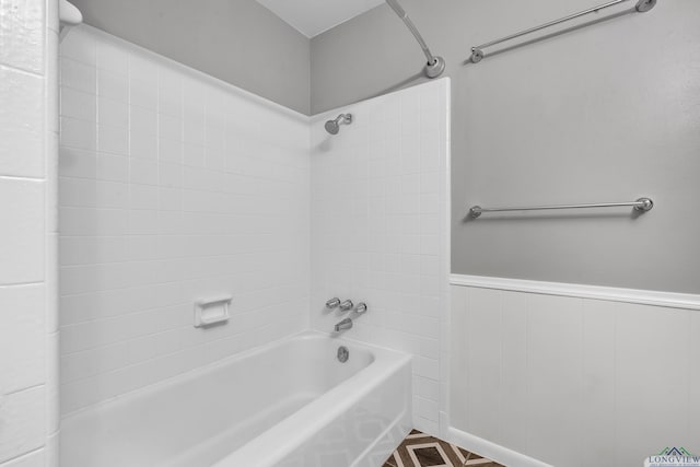 full bath with wainscoting and shower / washtub combination