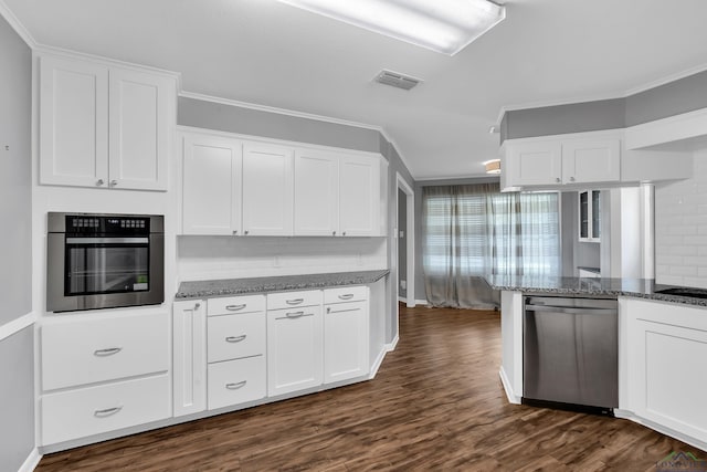kitchen featuring visible vents, crown molding, stainless steel appliances, and dark stone countertops