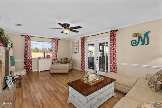 living room with crown molding, ceiling fan, light wood-type flooring, and french doors