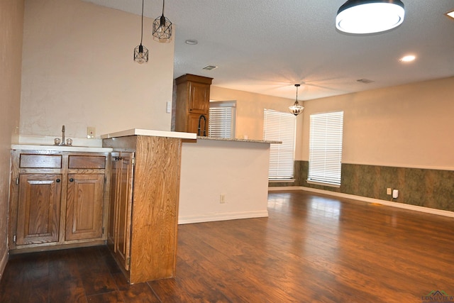 811 Georgia Ln, Longview, TX 75604 - kitchen featuring a peninsula, dark wood-style floors, light countertops, and hanging light fixtures