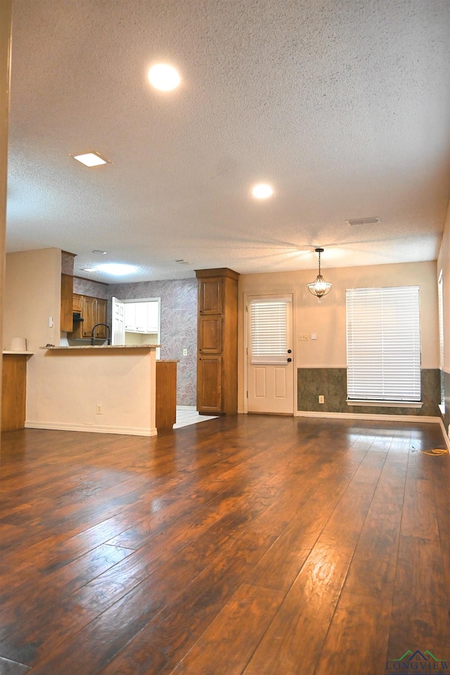811 Georgia Ln, Longview, TX 75604 - unfurnished living room featuring a textured ceiling, dark wood finished floors, and recessed lighting