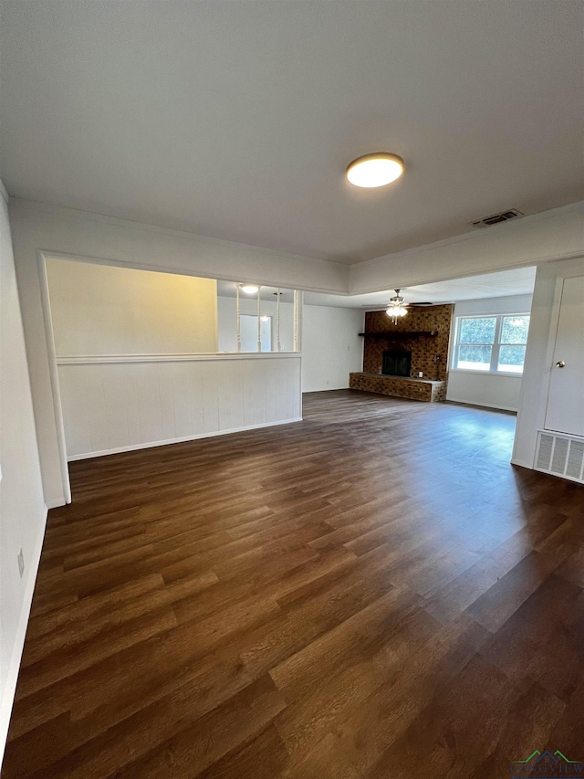 unfurnished living room featuring a fireplace, ceiling fan, and dark hardwood / wood-style flooring