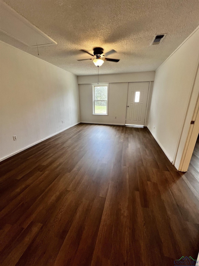 spare room with a textured ceiling, dark hardwood / wood-style flooring, and ceiling fan