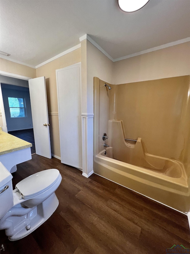 full bathroom featuring hardwood / wood-style flooring, toilet, shower / washtub combination, and ornamental molding