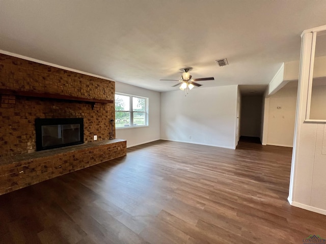 unfurnished living room featuring a fireplace, ceiling fan, and dark wood-type flooring