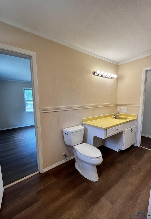 bathroom featuring hardwood / wood-style floors, toilet, ornamental molding, and sink