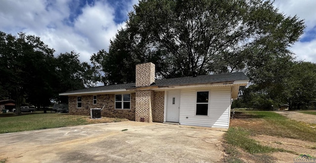 rear view of property featuring a yard and central AC unit