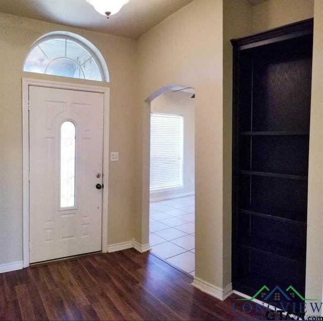 704 Cheryl St, Longview, TX 75604 - foyer featuring baseboards, arched walkways, and wood finished floors