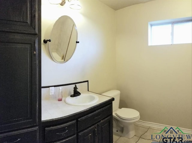 704 Cheryl St, Longview, TX 75604 - bathroom with vanity, tile patterned flooring, baseboards, and toilet
