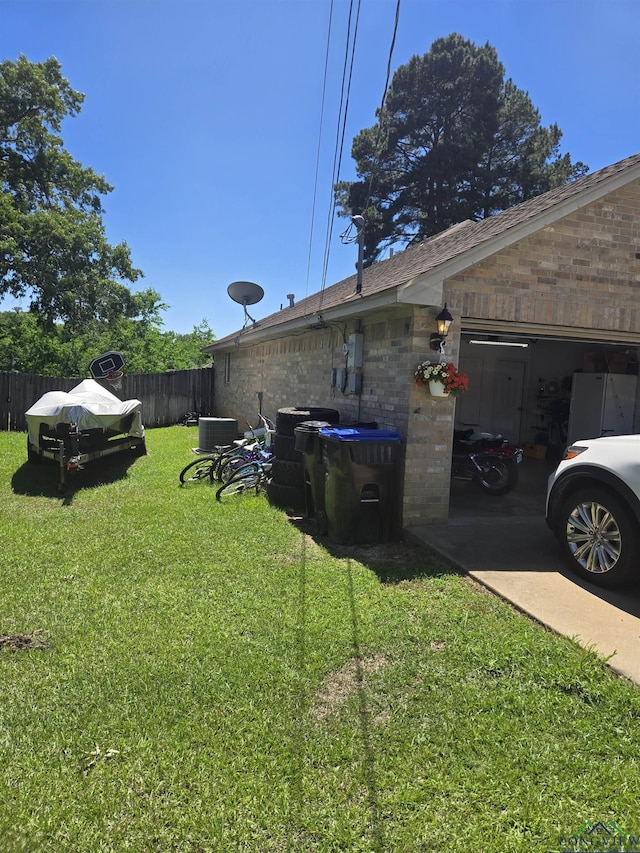 704 Cheryl St, Longview, TX 75604 - view of yard featuring fence, central AC unit, and a garage