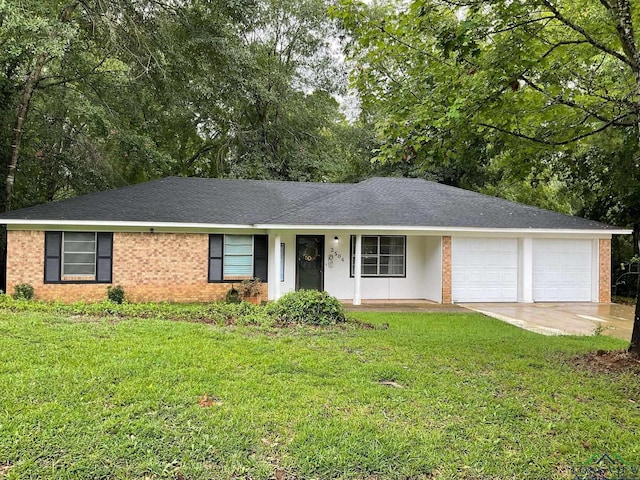 ranch-style home featuring covered porch, a garage, and a front yard