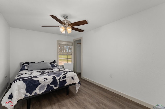 bedroom with a ceiling fan, baseboards, and wood finished floors