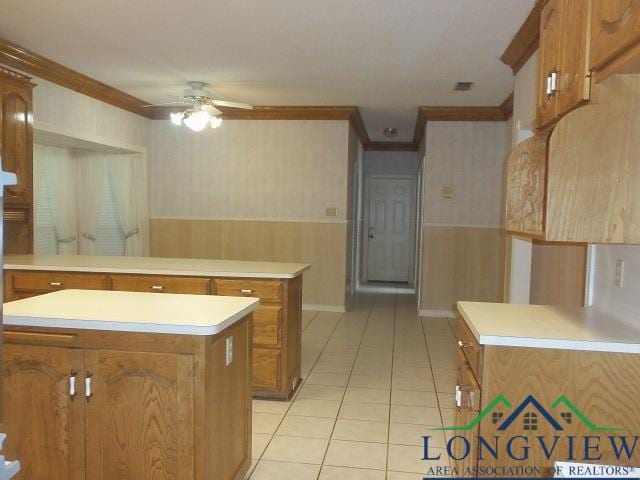 404 Moccasin Trl, Kilgore, TX 75662 - kitchen featuring brown cabinetry, a peninsula, crown molding, a ceiling fan, and light tile patterned flooring