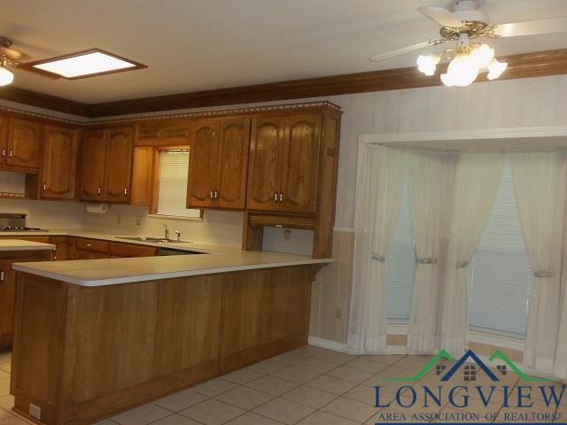 404 Moccasin Trl, Kilgore, TX 75662 - kitchen with ceiling fan, light countertops, a sink, and brown cabinets
