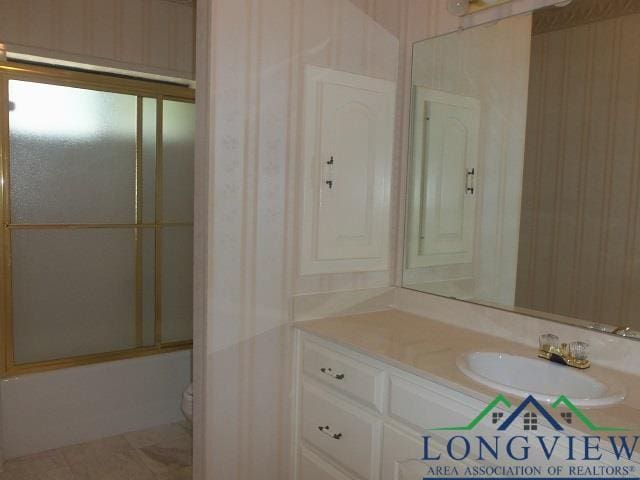 404 Moccasin Trl, Kilgore, TX 75662 - bathroom featuring vanity, wallpapered walls, shower / bath combination with glass door, and tile patterned floors