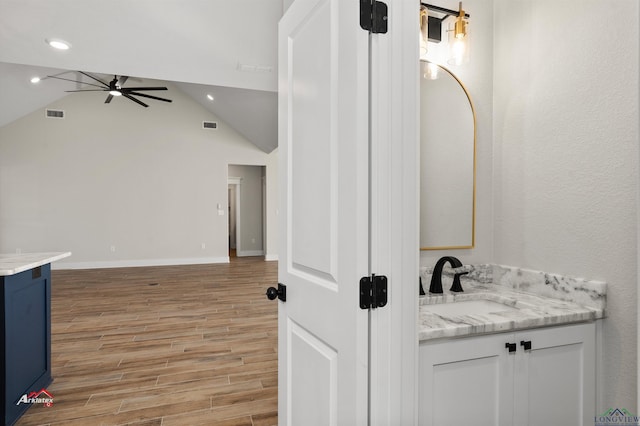 bathroom featuring vanity, ceiling fan, and lofted ceiling