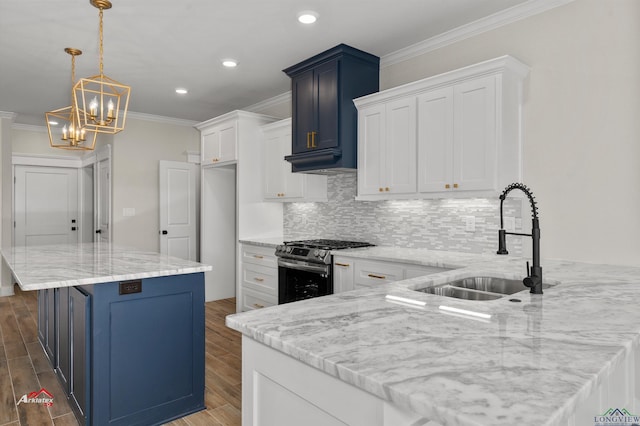 kitchen featuring pendant lighting, white cabinets, sink, tasteful backsplash, and gas stove